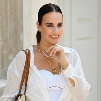 a woman wearing a white shirt and a brown purse