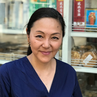 a woman standing in front of a bakery