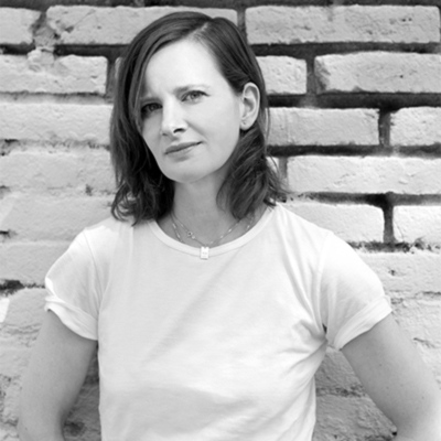 a woman standing in front of a brick wall