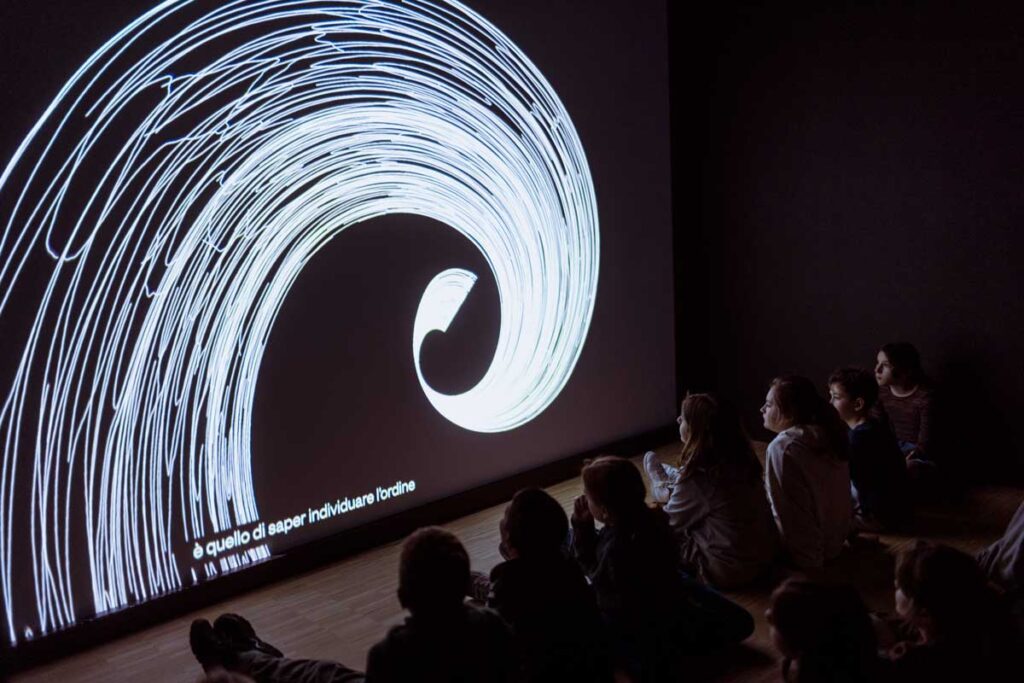 a group of people sitting in front of a projection screen